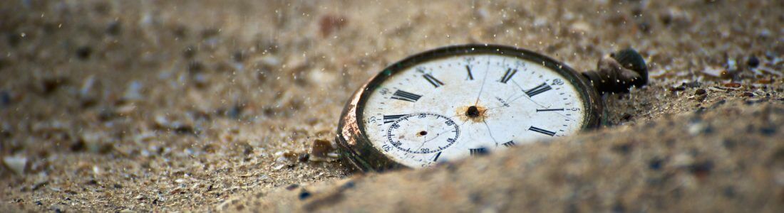 Stopped watch buried in sand signifying life expectancy